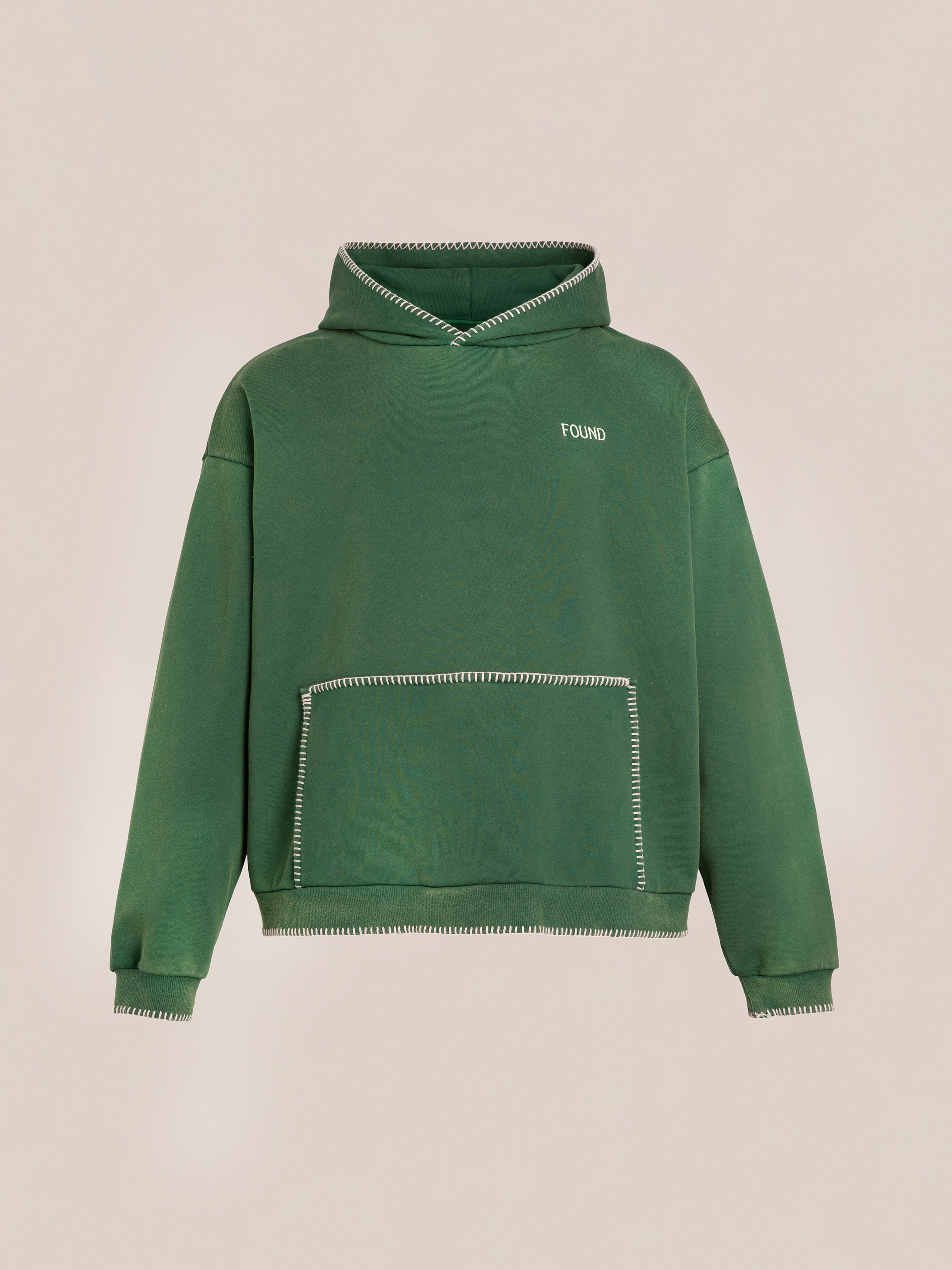 The FOUND Stitched Border Distressed Logo Hoodie in green, featuring white stitching, a front pocket, and the brand name "FOUND" embroidered on the left chest, offers an oversized hoodie fit and a vintage feel.