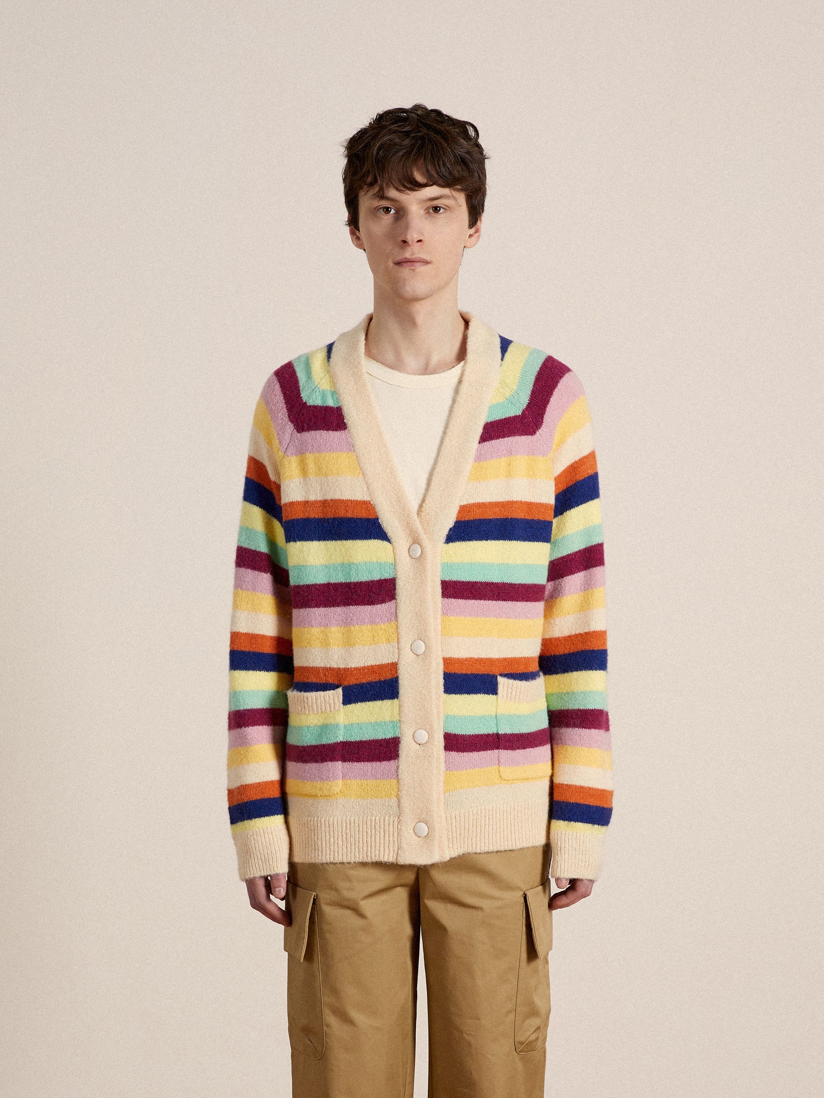 A man wearing a Found Razi Multi Stripe Cardigan in vibrant hues.